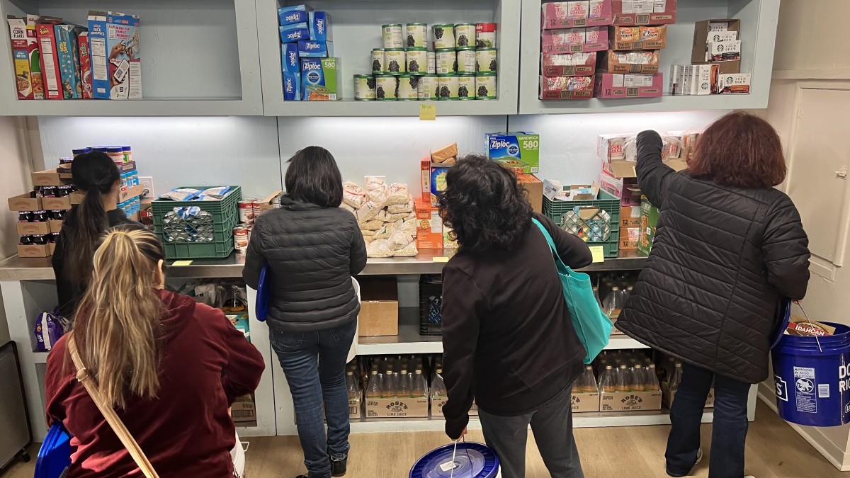 Grant recipients organizing food donation items in a commercial-sized pantry